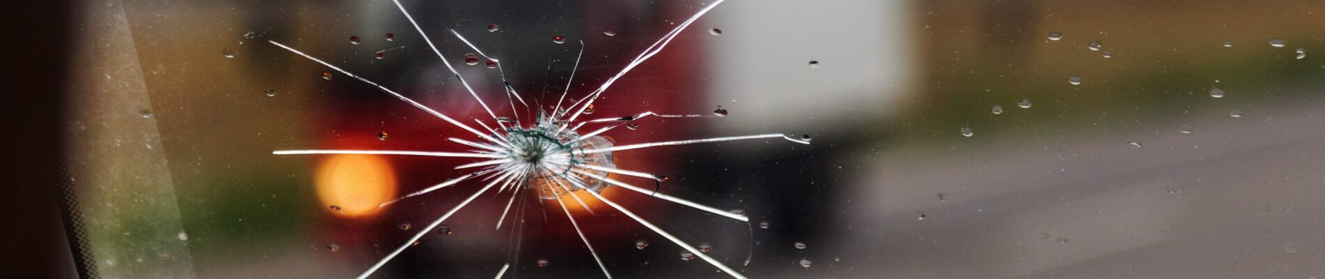 Parebrise éclat Broken windshield of a car. A web of radial splits, cracks on the triplex windshield. Broken car windshield, damaged glass with traces of oncoming stone on road or from bullet trace in car glass